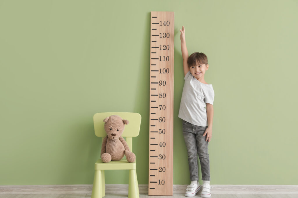 boy next to measuring stick